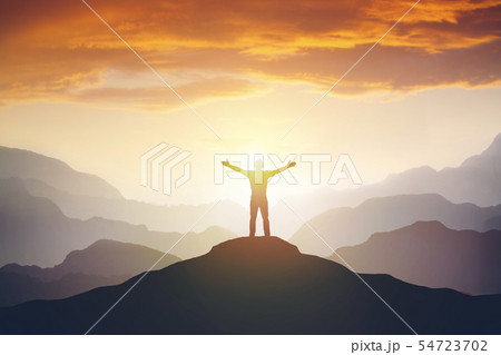 Climber arms up outstretched on mountain top looking at inspirational landscape. 54723702