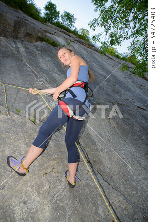 young woman climbing a rock wall young woman climbing a rock wall 54725403