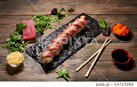 Serving sushi rolls and other traditional japanese and asian food on a table Serving sushi rolls and other traditional japanese and asian food on a table 54725999