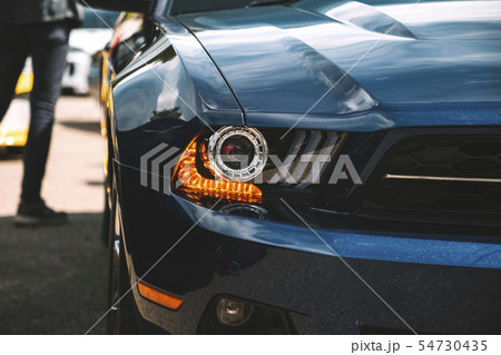Modern luxury car headlight. Man next to the classic american car. Trendy photo effect. Modern luxury car headlight. Man next to the classic american car. Trendy photo effect. 54730435