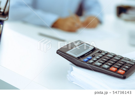 Calculator and binders with papers are waiting to be processed by business woman or bookkeeper back Calculator and binders with papers are waiting to be processed by business woman or bookkeeper back 54736143