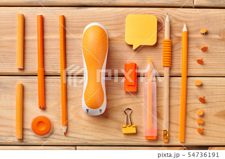 Orange stationery supplies on wooden background. Orange stationery supplies on wooden background. 54736191
