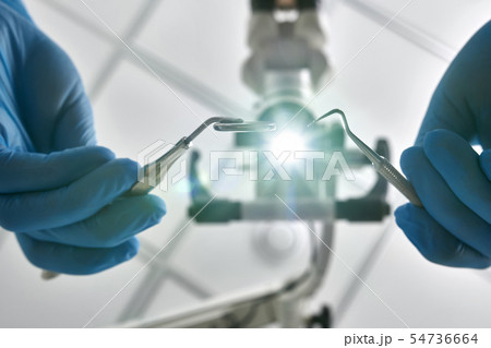 Dentist is using dental microscope during his work 54736664