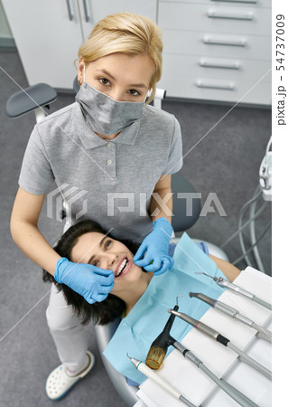 Pretty woman's teeth cleaning in dental clinic 54737009