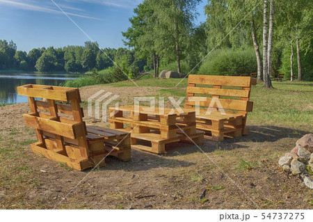 Rustic wooden table and benches at a lake 54737275