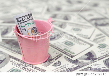 A bundle of US dollars in a metal pink bucket on a A bundle of US dollars in a metal pink bucket on a 54737517