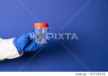 Doctor's hand in latex blue gloves holds a plastic 54738236