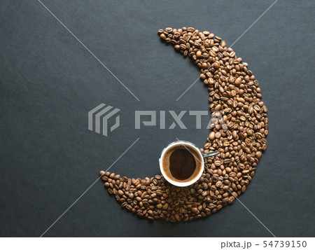 Crescent shape made of coffee beans and cup coffee Crescent shape made of coffee beans and cup coffee 54739150