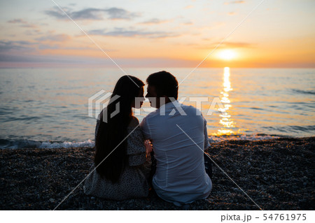 Photo of young loving couple at the beach at sunset. 54761975