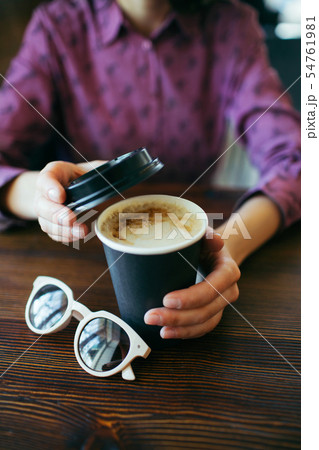 Female hands holding a cup of coffee. 54761981