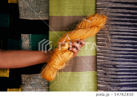 Natural yellow silk on colourful fabric background Natural yellow silk on colourful fabric background 54762830