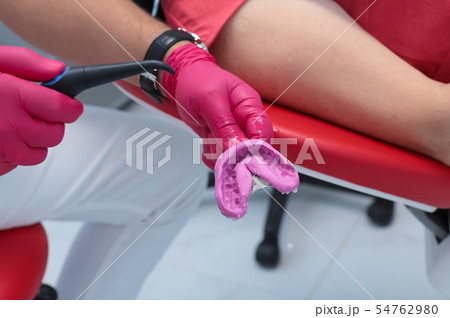 the dentist washes the impression with water 54762980