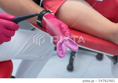 the dentist washes the impression with water 54762981