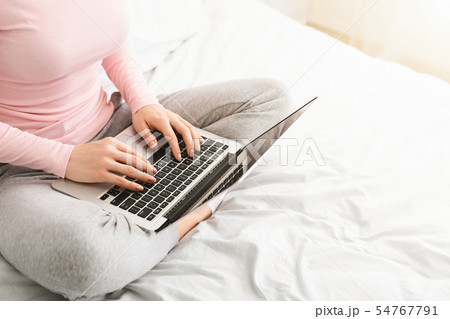 Woman journalist typing on laptop in bed 54767791