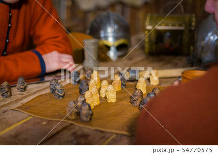 Two men playing popular strategy board game - tafl Two men playing popular strategy board game - tafl 54770575