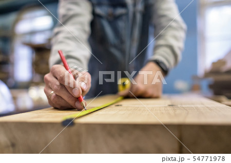 Carpenter measuring and tracing line with a ruler Carpenter measuring and tracing line with a ruler 54771978