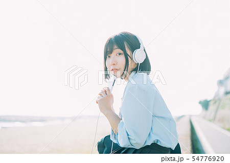 海の近くで音楽を聴く女子高生 海の近くで音楽を聴く女子高生 54776920