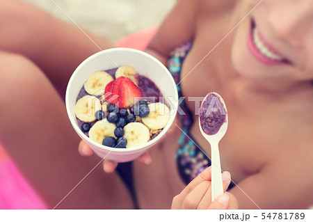 Acai bowl - girl eating healthy food on beach 54781789