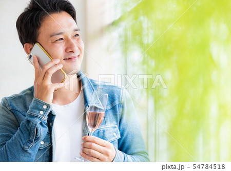 男性　カジュアル　スマホ　スパークリングワイン 54784518