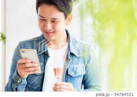 男性　カジュアル　スマホ　スパークリングワイン 54784521