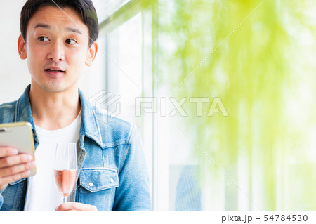 男性　カジュアル　スマホ　スパークリングワイン 54784530