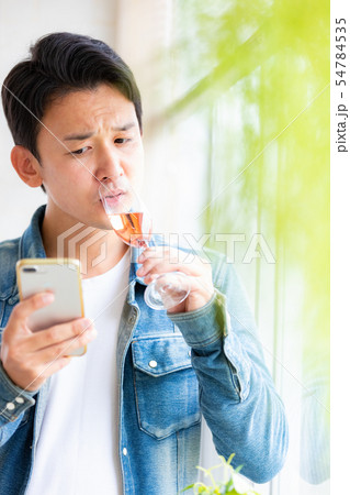 男性　カジュアル　スマホ　スパークリングワイン 54784535