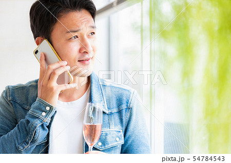 男性　カジュアル　スマホ　スパークリングワイン 54784543