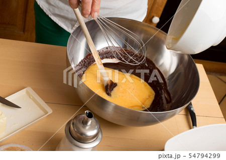 Woman hands mixing chocolate with eggs Woman hands mixing chocolate with eggs 54794299