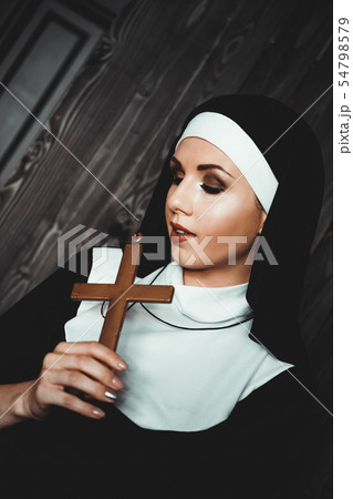 Sexy nun prays indoor. Beautiful young holy sister. 54798579