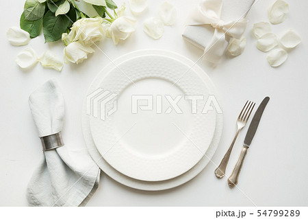 White table setting with bouquet rose, gift. White table setting with bouquet rose, gift. 54799289