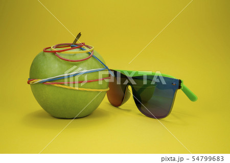 Apple tied in rubber bands and fashion sunglasses 54799683
