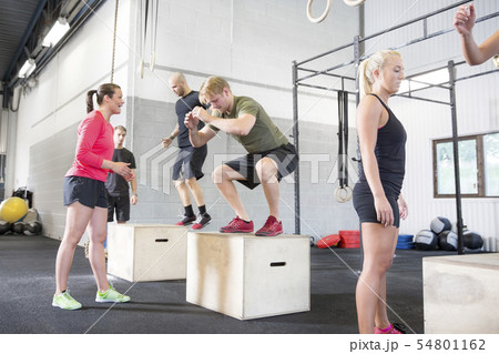 Workout group trains box jumps 54801162