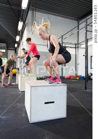 Workout group trains box jumps at the fitness gym 54801165
