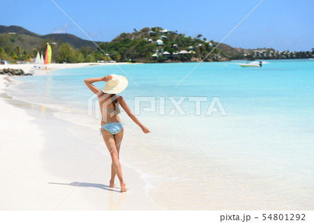Beach travel woman bikini wearing sun hat walking 54801292
