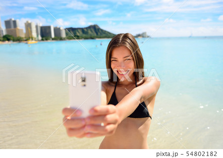 Girl taking fun smartphone selfie on Waikiki beach Girl taking fun smartphone selfie on Waikiki beach 54802182