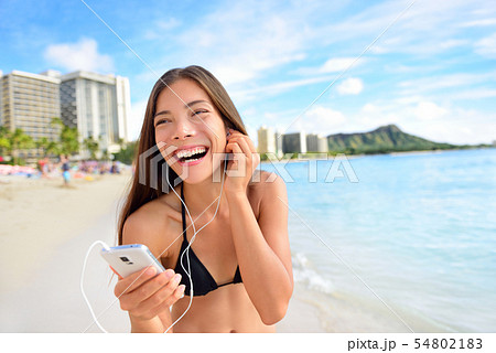 Happy beach woman listening to music on smartphone Happy beach woman listening to music on smartphone 54802183