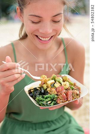 Woman eating local Hawaii food Poke bowl salad 54802382
