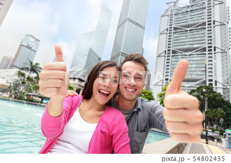 Happy thumbs up multicultural couple in Hong Kong Happy thumbs up multicultural couple in Hong Kong 54802435