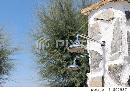 Outdoor shower sprinkler at the beach. Shower heads beside the pool. Cooling, refreshment concept at Outdoor shower sprinkler at the beach. Shower heads beside the pool. Cooling, refreshment concept at 54802987