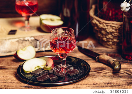 Glass of homemade currant nalivka and chocolate with apple Glass of homemade currant nalivka and chocolate with apple 54803035