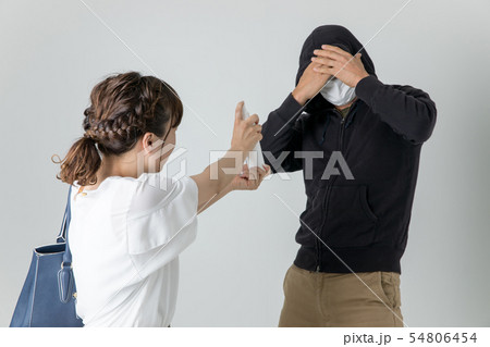 犯罪者に防犯スプレーをかける女性 54806454