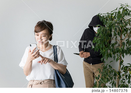 スマホで犯罪者に気づかない女性 54807376