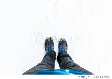 First person view of legs in hiking boots in the snow. Snow on boots while walking in winter 54811209
