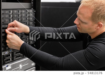 Male Technical Consultant Adjusting Hard Drives In SAN At Datace 54813176