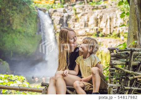 Mom and son tourists on the background of a waterfall. Traveling with kids concept. What to do with Mom and son tourists on the background of a waterfall. Traveling with kids concept. What to do with 54817982
