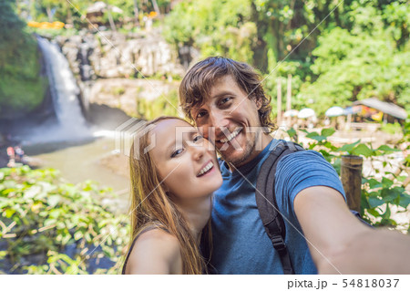 smiling couple, man and woman making selfie on a waterfall background 54818037