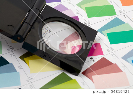 Glass loupe standing on colour swatch Glass loupe standing on colour swatch 54819422