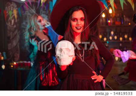 Portrait of beautiful girl with a big hat dressed up like a witch for halloween celebration 54819533