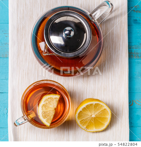 Glass cup of tea with lemon and glass teapot. Glass cup of tea with lemon and glass teapot. 54822804