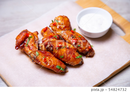 BBQ chicken wings with sauce on paper. 54824732